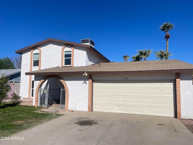 view of property featuring a garage and cooling unit