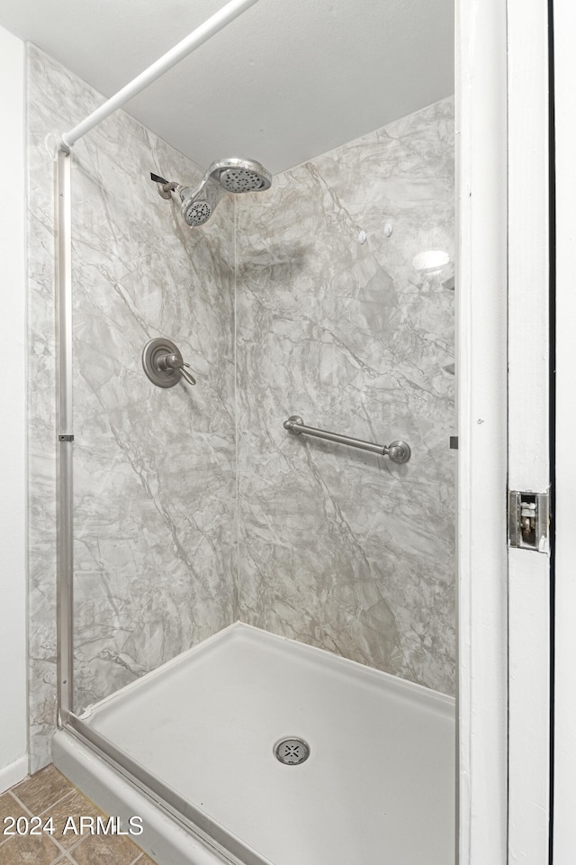 bathroom featuring tile patterned flooring and a tile shower