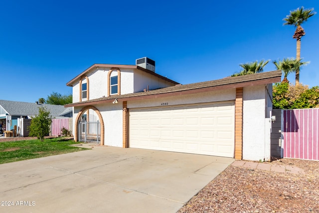 view of front of house with a garage and central AC