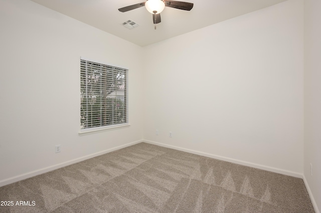 carpeted empty room with ceiling fan, visible vents, and baseboards