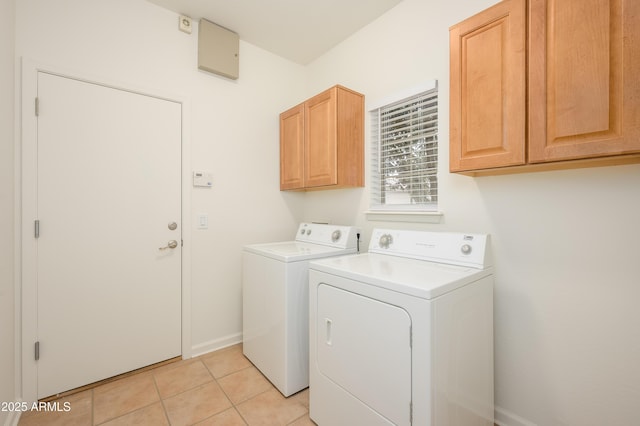 laundry room with light tile patterned flooring, independent washer and dryer, cabinet space, and baseboards