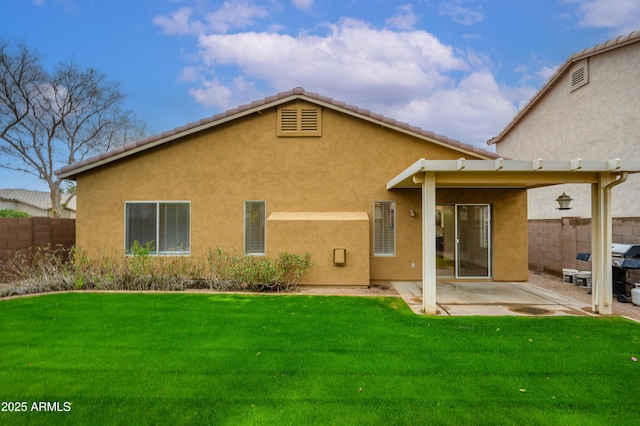 back of property featuring a yard, fence, and stucco siding