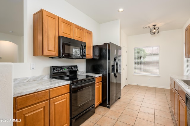 kitchen featuring light countertops, visible vents, black appliances, and light tile patterned floors