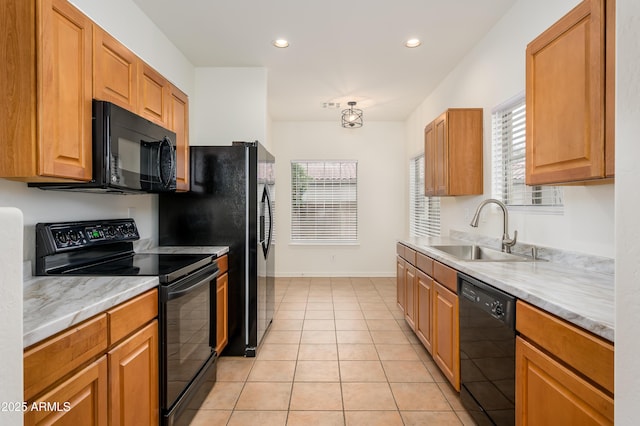 kitchen with light tile patterned floors, plenty of natural light, light countertops, black appliances, and a sink