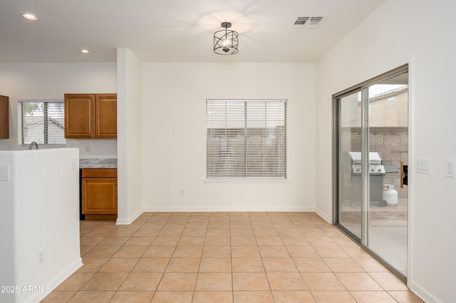 unfurnished dining area featuring baseboards, light tile patterned flooring, visible vents, and recessed lighting