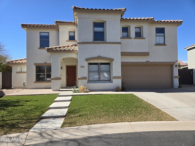 mediterranean / spanish-style house featuring driveway, a tiled roof, an attached garage, a front lawn, and stucco siding