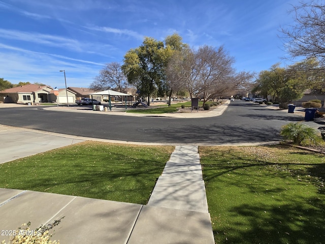 view of road featuring sidewalks, street lighting, and a residential view