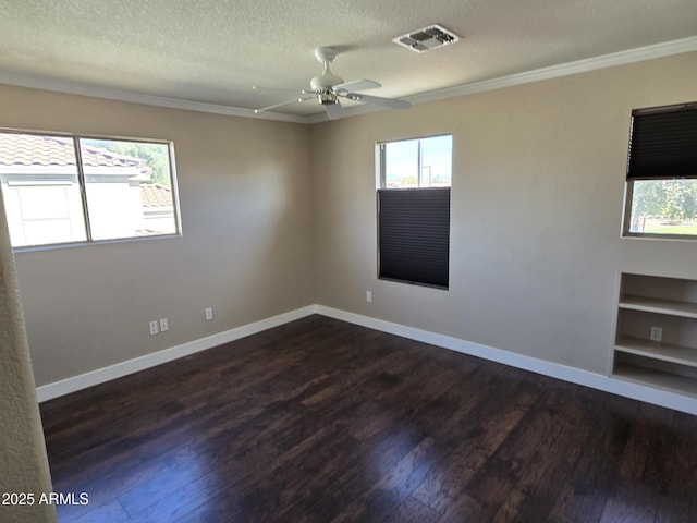 unfurnished room with a textured ceiling, dark wood finished floors, visible vents, and baseboards