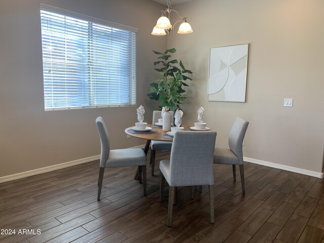 empty room with hardwood / wood-style flooring and a notable chandelier