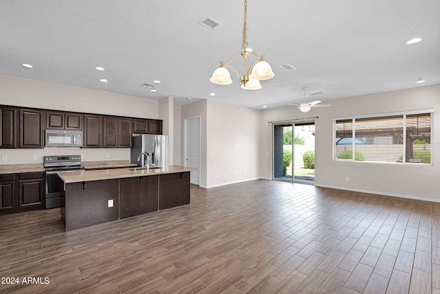 kitchen featuring electric range, dark brown cabinets, dark hardwood / wood-style floors, and a center island with sink