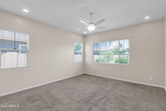 carpeted spare room with ceiling fan