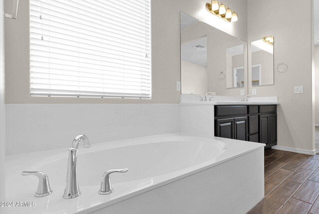 bathroom with vanity, a bathing tub, and hardwood / wood-style floors