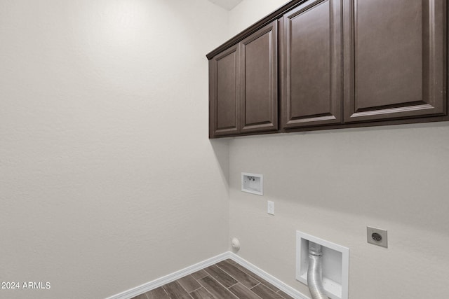 laundry area with cabinets, hookup for an electric dryer, gas dryer hookup, washer hookup, and dark wood-type flooring