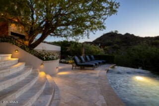 pool at dusk with a patio