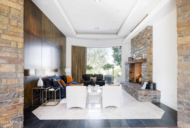 living room featuring a raised ceiling and a large fireplace