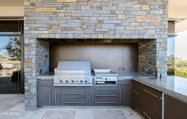 view of patio / terrace featuring area for grilling, exterior kitchen, sink, and exterior fireplace