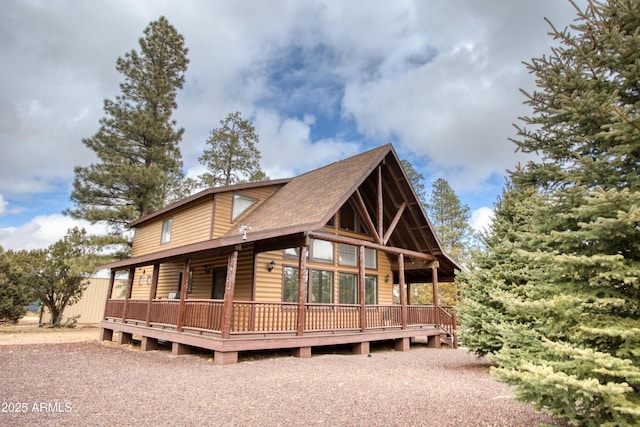 view of front of home with roof with shingles and a wooden deck