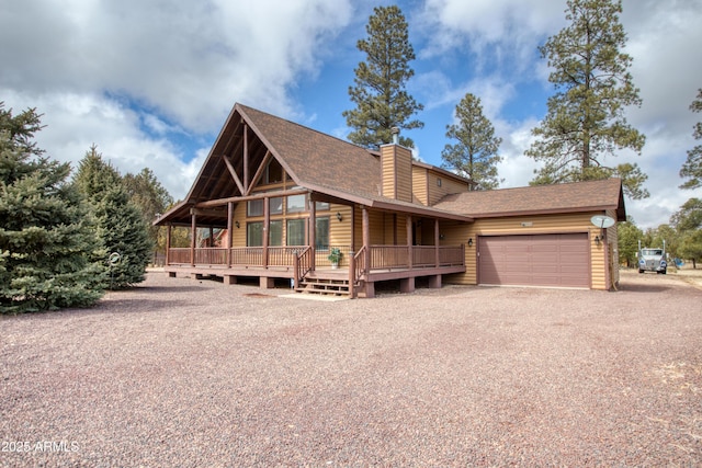 rustic home featuring roof with shingles, an attached garage, driveway, and a chimney