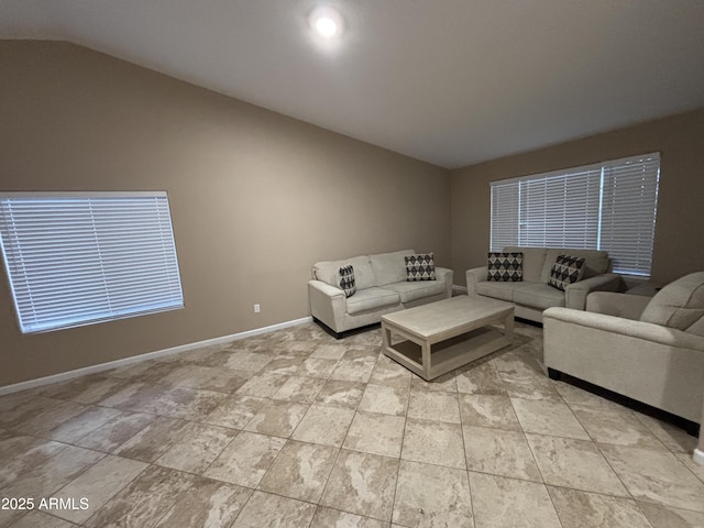 living area with lofted ceiling and baseboards