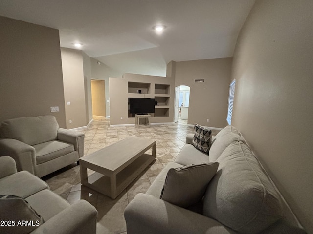 living room featuring built in shelves, baseboards, and lofted ceiling