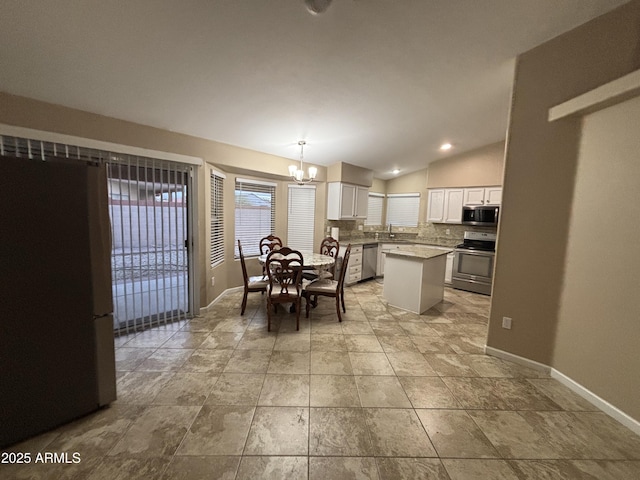 dining space with baseboards, a chandelier, and vaulted ceiling