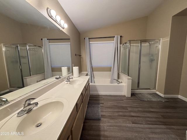 bathroom with a sink, a stall shower, wood finished floors, and vaulted ceiling