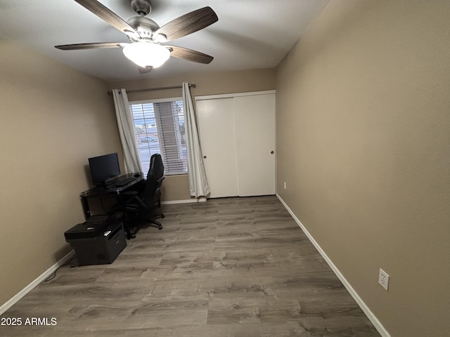 unfurnished office featuring ceiling fan, baseboards, and wood finished floors