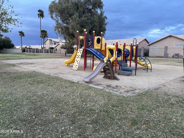 community jungle gym featuring a lawn and fence