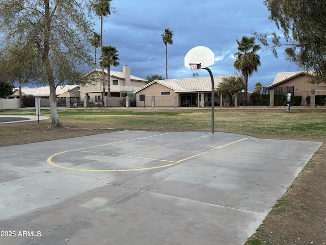 view of basketball court with community basketball court, fence, and a lawn