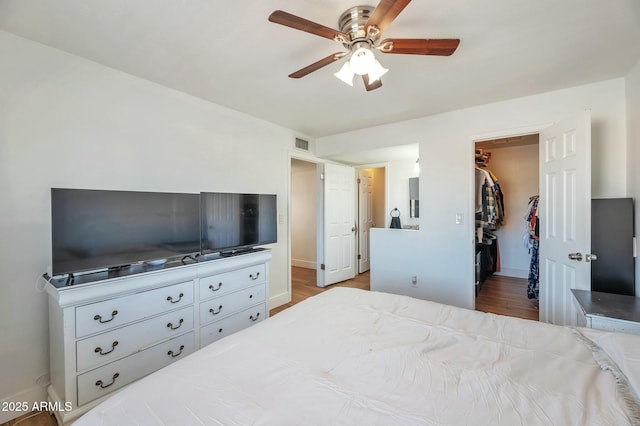 623 W Guadalupe Rd Unit 213, Mesa, AZ 85210 - bedroom with a spacious closet, visible vents, a ceiling fan, a closet, and baseboards