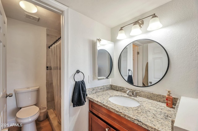 623 W Guadalupe Rd Unit 213, Mesa, AZ 85210 - full bath with a tile shower, toilet, visible vents, wood finished floors, and vanity