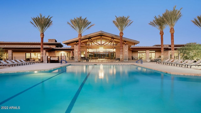 pool at dusk with a patio area