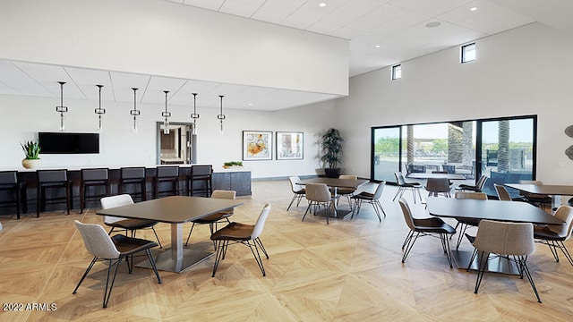 dining area featuring a high ceiling and light parquet floors