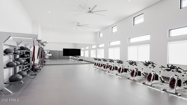 exercise room featuring ceiling fan and a high ceiling