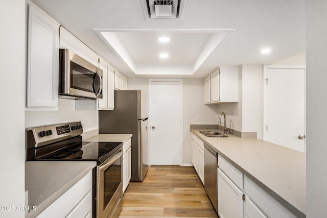 222 W Brown Rd Unit 14, Mesa, AZ 85201 - kitchen with appliances with stainless steel finishes, a raised ceiling, light wood-type flooring, recessed lighting, and white cabinets