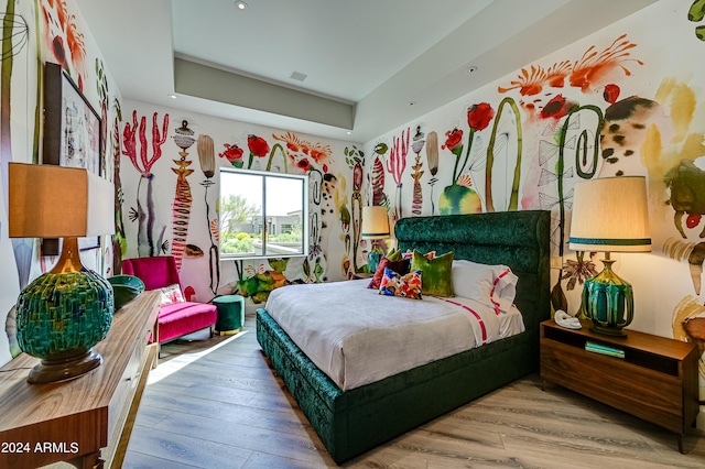 bedroom with hardwood / wood-style flooring and a raised ceiling