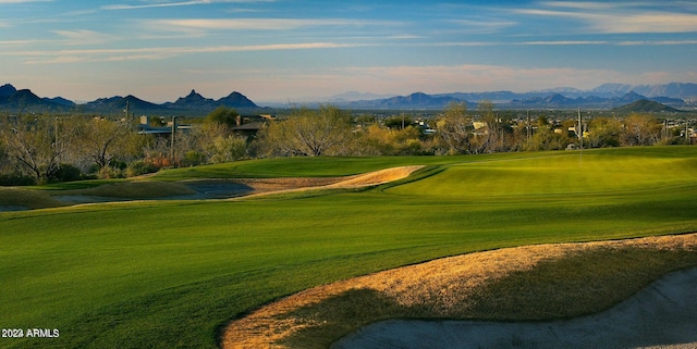 view of property's community with a mountain view and a lawn