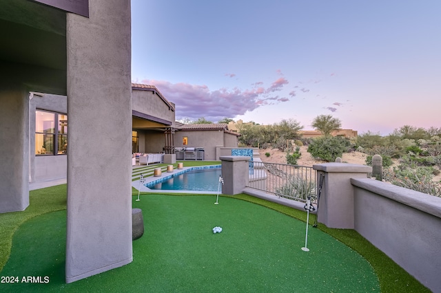 pool at dusk with a patio area