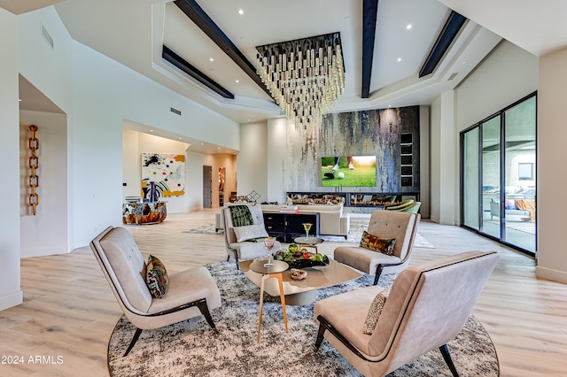 living room featuring beamed ceiling, light hardwood / wood-style flooring, and a high ceiling