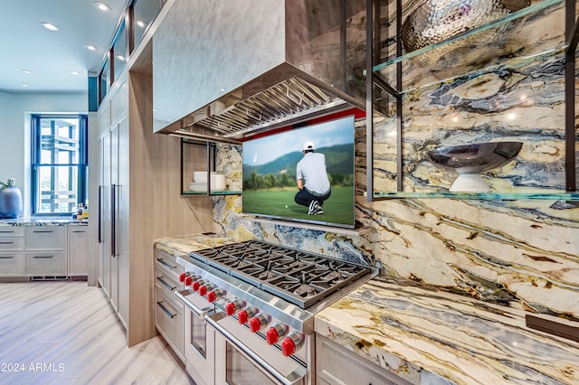 kitchen featuring custom range hood, double oven range, backsplash, and light hardwood / wood-style flooring