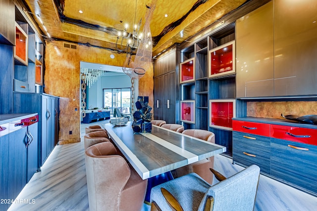 interior space featuring a high ceiling, an inviting chandelier, and light hardwood / wood-style flooring