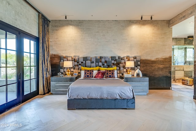 bedroom featuring french doors, light parquet floors, and track lighting