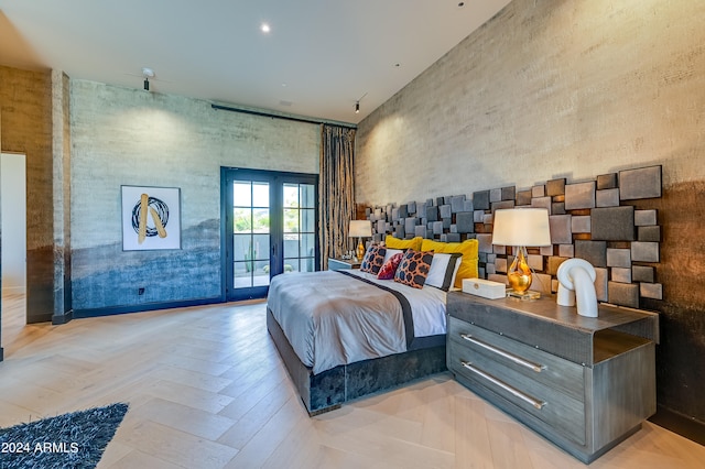 bedroom with french doors, light parquet floors, a towering ceiling, and access to outside