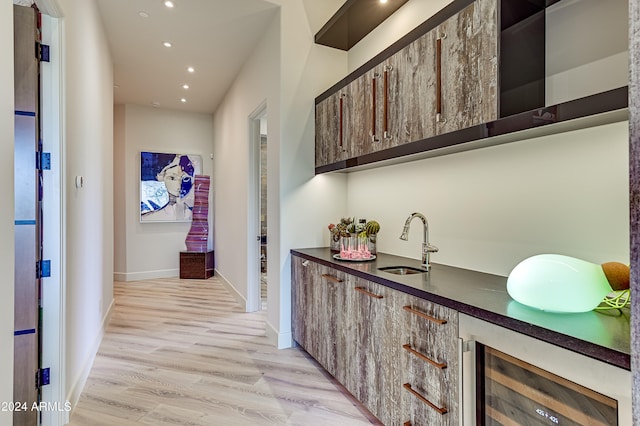 hall featuring beverage cooler, light hardwood / wood-style flooring, and sink