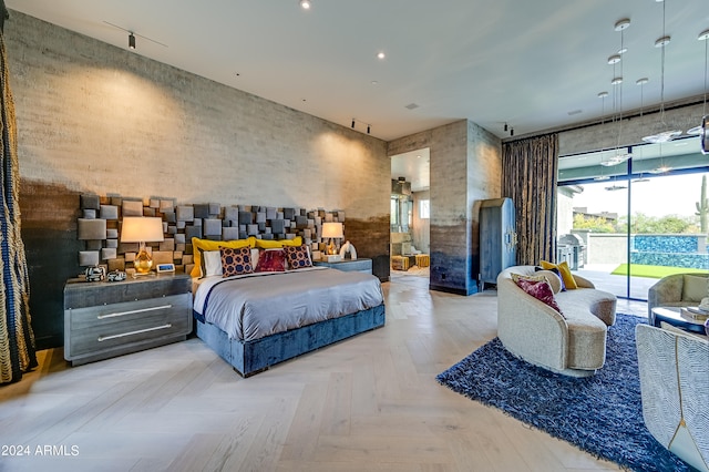 bedroom featuring access to outside, light parquet floors, and track lighting