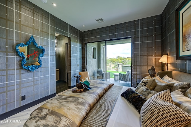 bedroom featuring tile patterned floors and tile walls