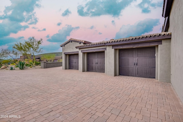 view of garage at dusk