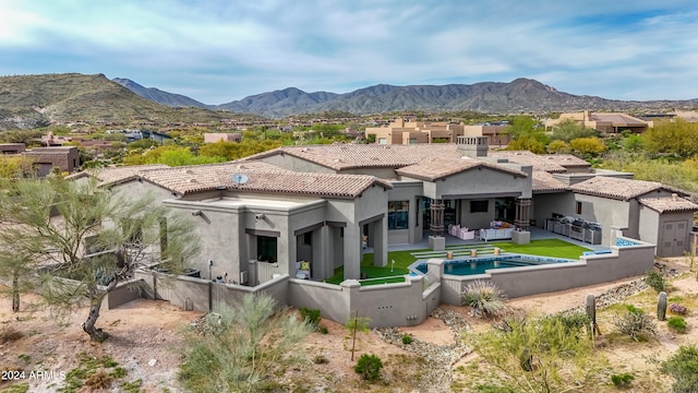 back of house featuring a mountain view and a patio area