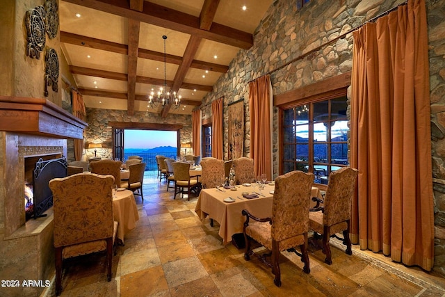 dining area with a water view, beamed ceiling, and a notable chandelier