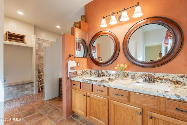full bathroom featuring double vanity, tiled shower, a sink, and recessed lighting